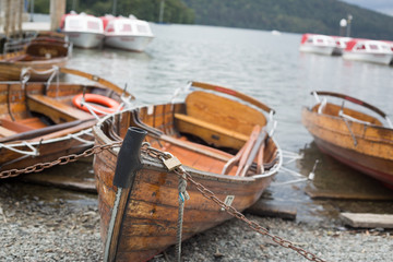 Fototapeta na wymiar Boats moored on pebble beach on the edge of Lake Windermere 
