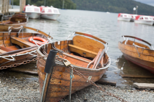 Boats moored on pebble beach on the edge of Lake Windermere 