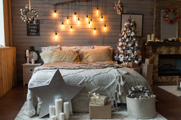 Cosy bedroom with eco decor. Wood and nature concept in interior of room. Scandinavian interior with christmas tree, real photo. Hygge decoration. Christmas concept.