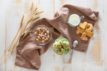 Tasty pistachio ice cream with milk and cookies on wooden table
