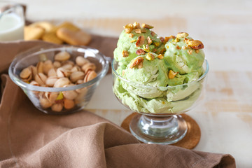 Bowl with tasty pistachio ice cream on table
