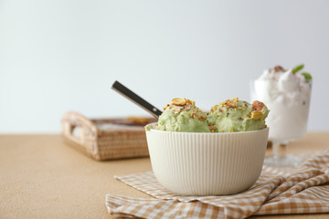 Bowl with tasty pistachio ice cream on table