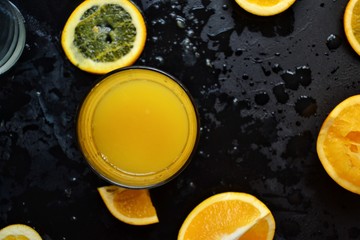 Fototapeta na wymiar Freshly squeezed orange juice. Orange and orange juice on a dark background. 