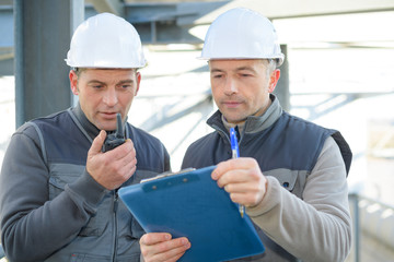 engineers holding a clipboard and walkie-talkie