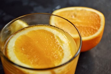 Freshly squeezed orange juice.  Orange and orange juice on a dark background. 