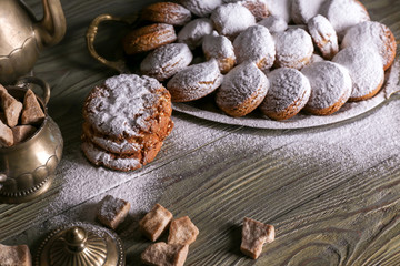 Tasty cookies with sugar powder on wooden table