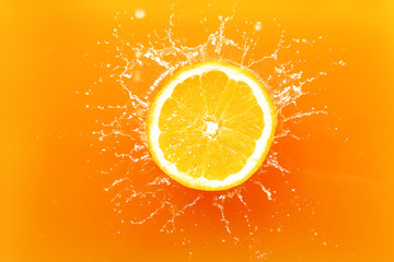 Falling of orange piece into juice, top view