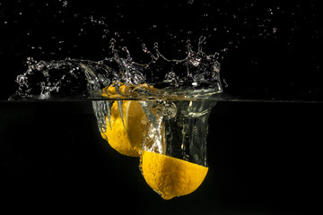 Lemon splashing into water - obrazy, fototapety, plakaty