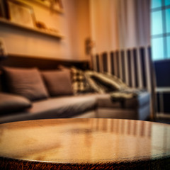 Wooden coffee table of free space for your decoration and blurred background of home interior. 