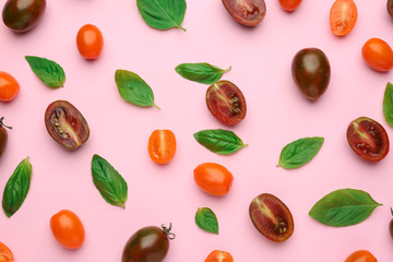 Different fresh tomatoes with basil on color background