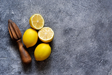 Lemons and juicer on stone background. Top view with copy space.