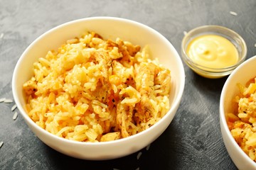 Rice in a white bowl. Rice dish on a dark table background. Pilaf, rice porridge, cooked rice with vegetables. Healthy vegetarian food.