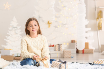 Cute little girl with Christmas gifts at home