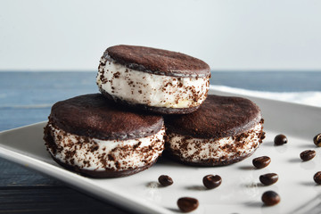 Tasty ice cream cookie sandwiches on plate
