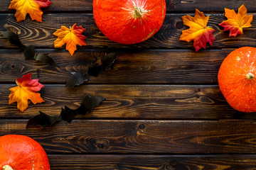 Autumn background with pumpkins and leaves on dark wooden table top view frame space for text