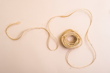 Skein of jute twine isolated on light beige natural background