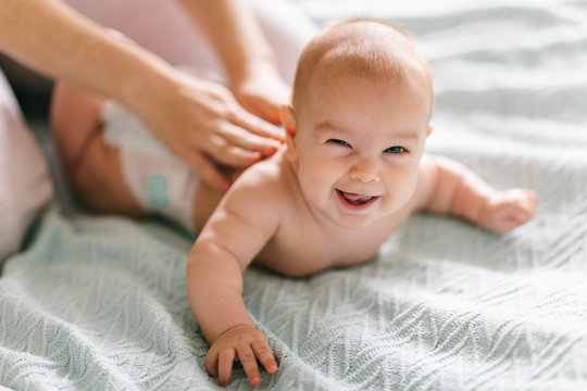 Massage for the baby. Four month old baby smiling doing gymnastics