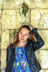 Young girl straightens red hair looking at the camera standing