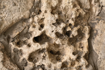 Closeup of rough ancient stone, relief structure, concrete texture wall. Uneven surface with pimples. For modern background