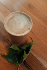 Paper coffee cup from coffee shop on wooden background