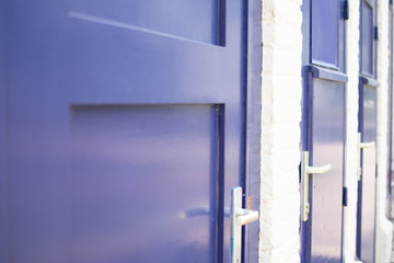 Close up of blue doors against white brick wall at a train station