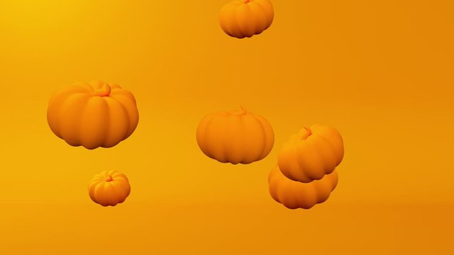 Pumpkins levitate on an orange background 
