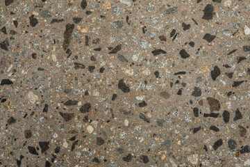 Gros plan texture béton désactivé avec graviers gris, noir et couleur