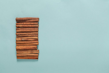 Naklejka na ściany i meble Cinnamon Sticks On Blue Background with copyspace