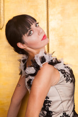 Fototapeta premium alluring sexy woman in evening dress posing over golden studio background
