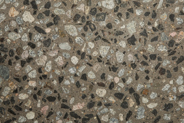 Gros plan texture béton désactivé avec graviers gris, noir et couleur