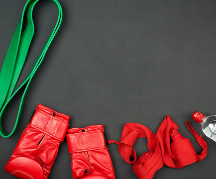 a pair of red leather boxing gloves, a textile bandage for bandaging the athlete’s hands, bottle of water