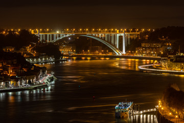 Fototapeta na wymiar City of Porto at night, looking over Douro River with Arrabida Bridge at distance