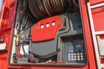 Modern control panel and extinguishing hose mounted on fire truck or fire engine, close-up
