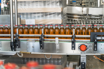 Conveyor belt, juice in glass bottles in automated machine equipment on beverage factory