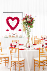 Red decor theme. Beautiful banquet a wedding reception. Interior of a wedding tent decoration ready for guests. Decor flowers.