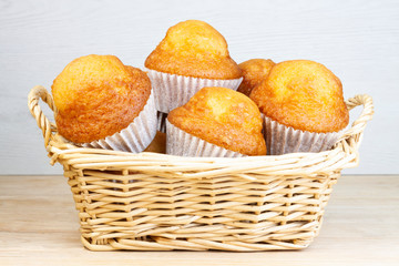 MUFFIN IN WICKER BASKET ON WOODEN TABLE AND CLEAR FUND