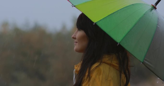 Woman standing under umbrella enjoy autumn rain on nature