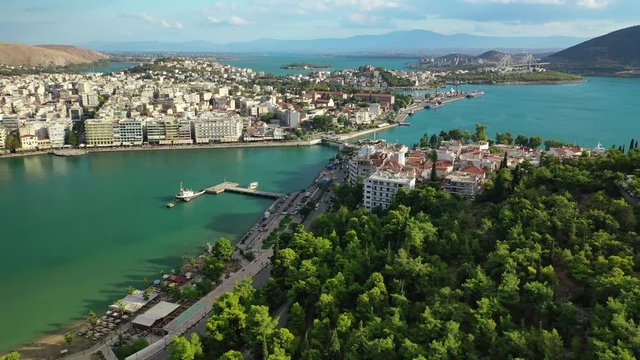 Aerial drone video of iconic town of Halkida or Chalkida with famous old bridge connecting Evoia island with mainland and beautiful clouds, Greece