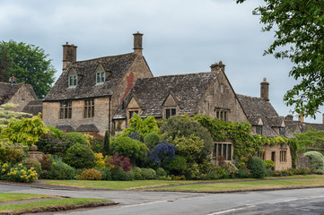 Fototapeta na wymiar BROADWAY, ENGLAND - MAY, 27 2018: Thatched cottages with climbing plants in the village of Broadway, in the English county of Worcestershire, Cotswolds, UK 