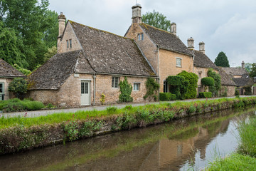 Fototapeta na wymiar LOWER SLAUGHTER, COTSWOLDS, GLOUCESTERSHIRE, ENGLAND - MAY, 27 2018: Typical Cotswold cottages on the River Eye, Lower Slaughter, Gloucestershire, Cotswolds, England, UK