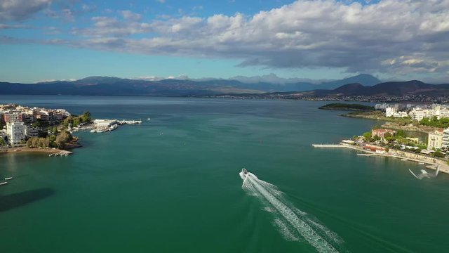 Aerial drone video of iconic town of Halkida or Chalkida with famous old bridge connecting Evoia island with mainland and beautiful clouds, Greece