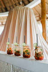 Set of four strawberry mojito cocktails. Slice of lime, glass bottle, black straw. Summer cold drink, vacations concept.