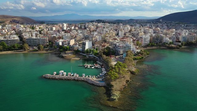 Aerial drone video of iconic town of Halkida or Chalkida with famous old bridge connecting Evoia island with mainland and beautiful clouds, Greece