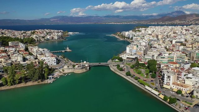 Aerial drone video of iconic town of Halkida or Chalkida with famous old bridge connecting Evoia island with mainland and beautiful clouds, Greece