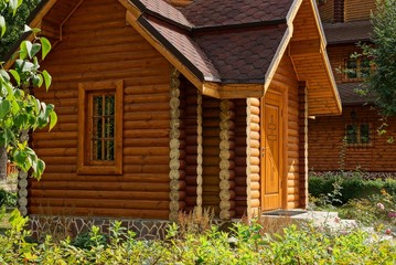 rural brown wooden house with window among green vegetation