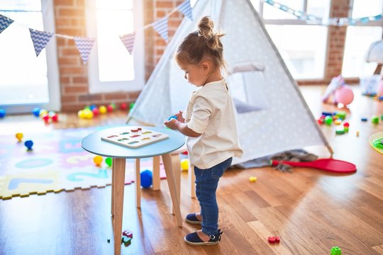 Young beautiful toddler learning mathematics playing with maths game at kindergaten