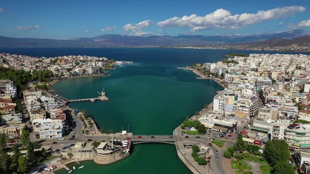 Aerial drone video of iconic town of Halkida or Chalkida with famous old bridge connecting Evoia island with mainland and beautiful clouds, Greece