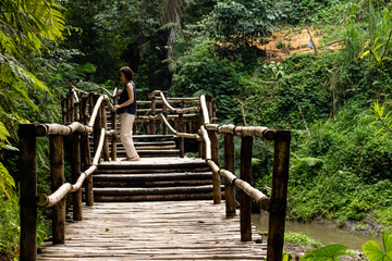 Young fashionable woman on a bamboo bridge