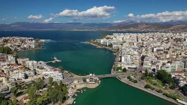 Aerial drone video of iconic town of Halkida or Chalkida with famous old bridge connecting Evoia island with mainland and beautiful clouds, Greece