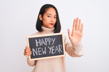 Young beautiful chinese woman holding blackboard over isolated white background with open hand doing stop sign with serious and confident expression, defense gesture